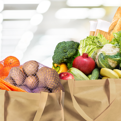 Fruits and vegetables in two brown paper bags.